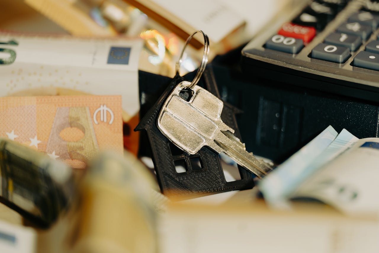 services-img House keys rest on a keychain with euro banknotes and calculator, symbolizing real estate investment.