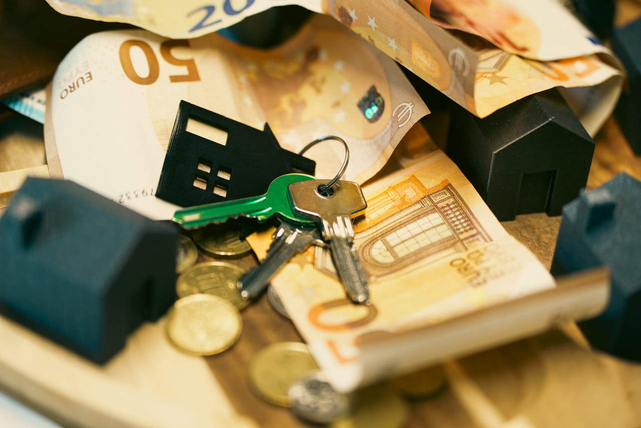 services-02 Euro currency with house keys and miniature models, symbolizing real estate investment.